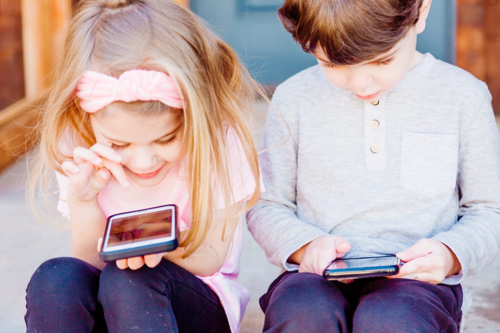 Kinderen met een eerste mobiele telefoon. 
