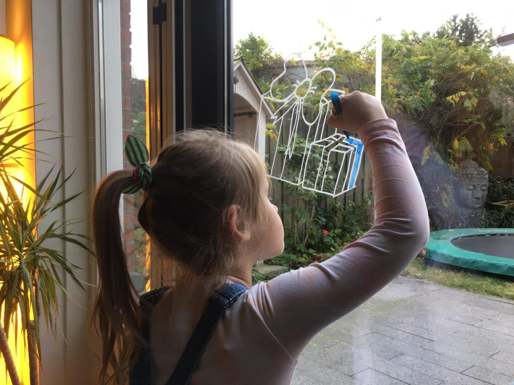 kind tekent op raam voor sinterklaas