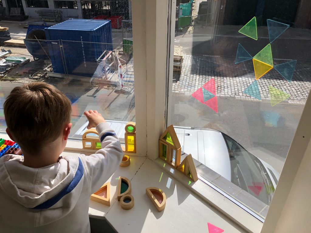 spelen in het raamkozijn tickit speelgoed  spiegelblokken en sensorische blokken. Montessori blokken voor thuis en klas. Regenboog blokken in de zon