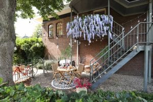 gezellige tuin met bloemborder, mooi zitje