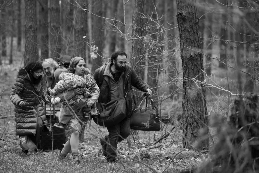 mensen vluchten in het bos tussen polen en rusland